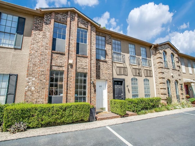 3817 Rawlins St Unit 103, Dallas, TX 75219 - view of front of house featuring uncovered parking and brick siding