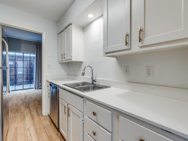 3817 Rawlins St Unit 103, Dallas, TX 75219 - kitchen with a sink, appliances with stainless steel finishes, light countertops, and white cabinetry