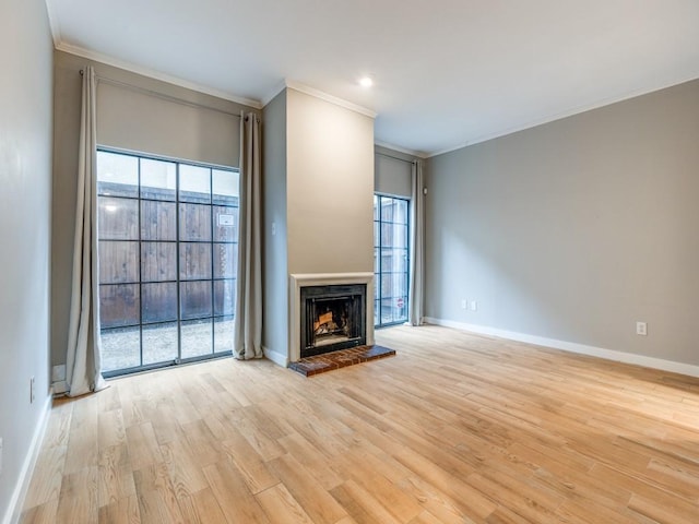 3817 Rawlins St Unit 103, Dallas, TX 75219 - unfurnished living room featuring ornamental molding, baseboards, a fireplace with raised hearth, and light wood-style floors
