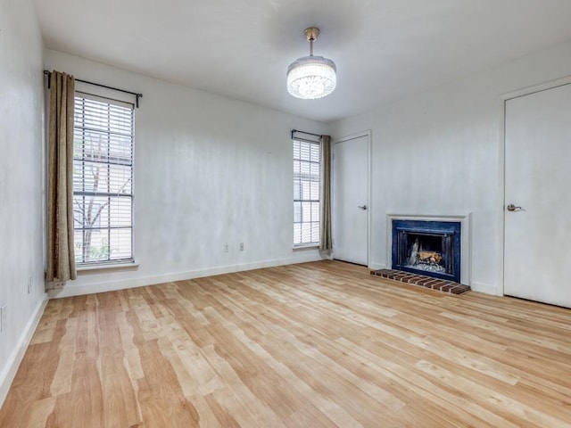 3817 Rawlins St Unit 103, Dallas, TX 75219 - unfurnished living room with wood finished floors, healthy amount of natural light, and a brick fireplace