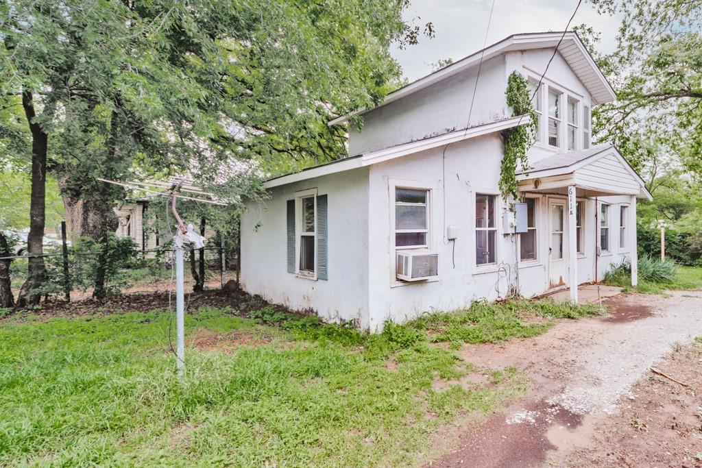 view of home's exterior with stucco siding, fence, and cooling unit