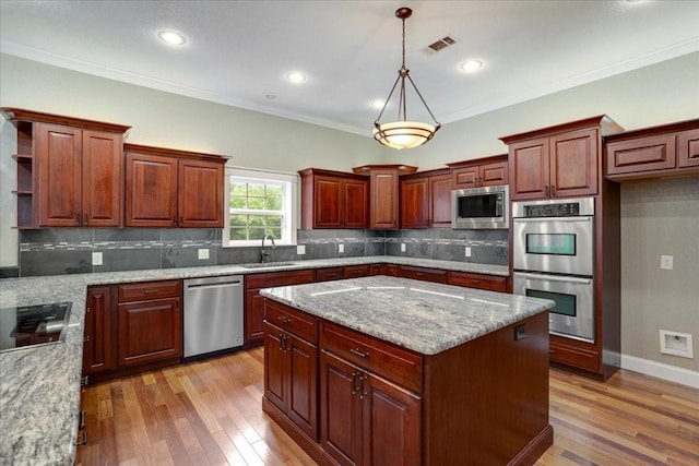 kitchen featuring a center island, a sink, light wood-style flooring, and appliances with stainless steel finishes