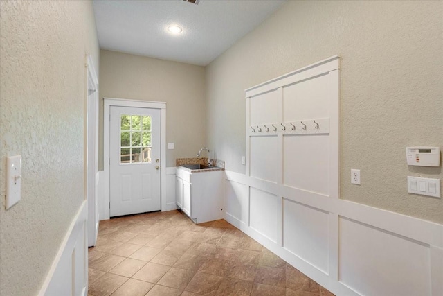 entryway featuring a sink, a textured wall, and recessed lighting