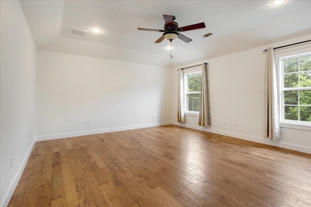 unfurnished room featuring visible vents, a wealth of natural light, and light wood finished floors
