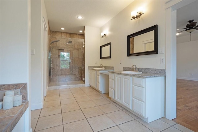 bathroom featuring a sink, baseboards, tile patterned flooring, and a shower stall