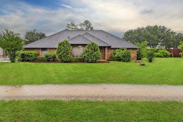 view of home's exterior with a shingled roof, fence, and a yard