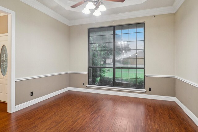 empty room with crown molding, a ceiling fan, baseboards, and wood finished floors
