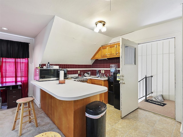 2802 Cinnamon Springs Rd, Glenn Heights, TX 75154 - kitchen featuring brown cabinets, light countertops, range, a peninsula, and stainless steel microwave