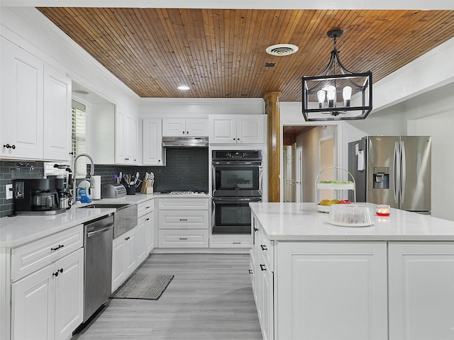 2802 Cinnamon Springs Rd, Glenn Heights, TX 75154 - kitchen with a center island, light countertops, under cabinet range hood, a sink, and stainless steel appliances