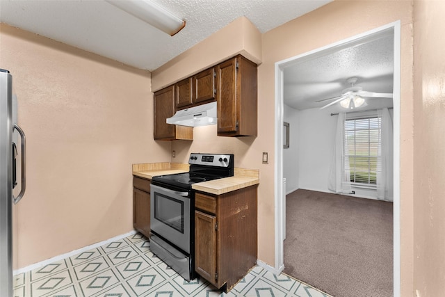 kitchen featuring ceiling fan, appliances with stainless steel finishes, a textured ceiling, baseboards, and under cabinet range hood