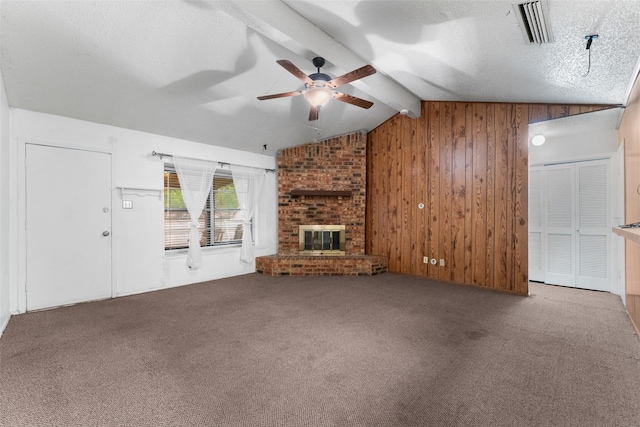 unfurnished living room with carpet flooring, lofted ceiling with beams, wood walls, a ceiling fan, and visible vents