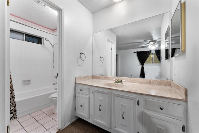 bathroom with vanity, toilet, a textured ceiling, tile patterned floors, and a ceiling fan