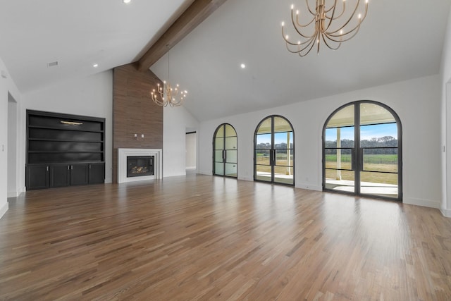 unfurnished living room featuring high vaulted ceiling, a chandelier, beam ceiling, and light wood-style flooring