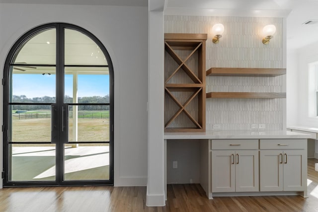 interior space featuring baseboards, wood finished floors, and visible vents
