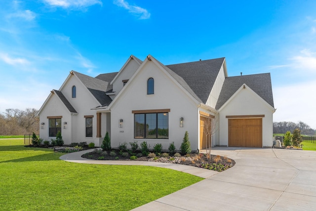 view of front of house with an attached garage, a front lawn, roof with shingles, and driveway