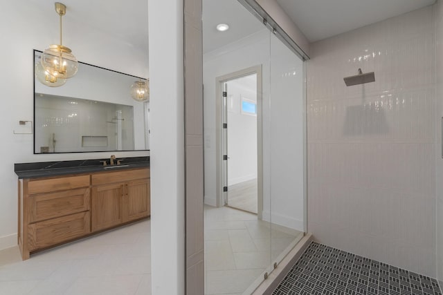 bathroom with vanity, baseboards, walk in shower, and tile patterned flooring