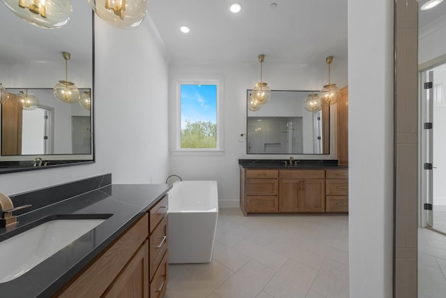 bathroom with recessed lighting, a sink, a freestanding tub, and two vanities