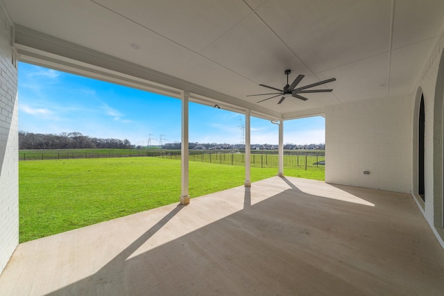 view of patio featuring ceiling fan, fence, and a rural view