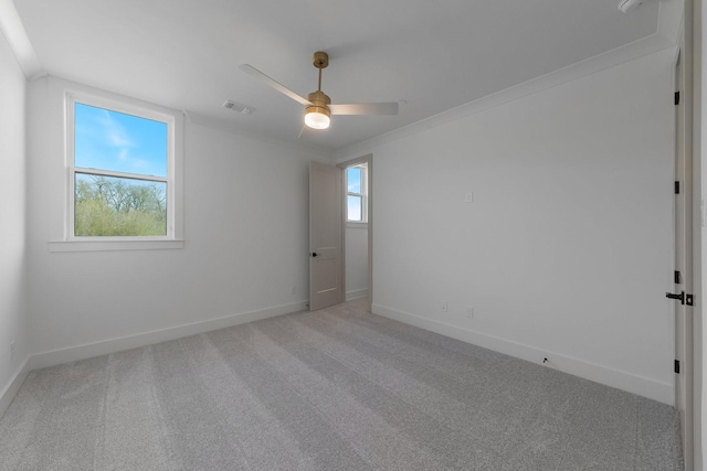 unfurnished room with ceiling fan, visible vents, light carpet, and baseboards