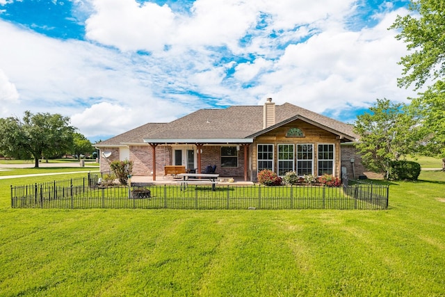 rear view of house with a chimney, a lawn, fence private yard, a patio area, and brick siding