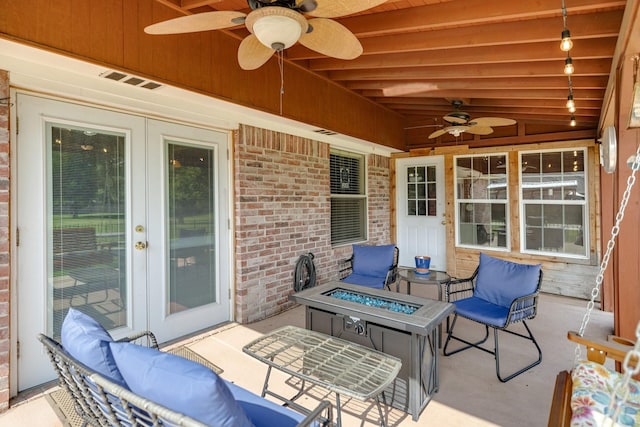 view of patio / terrace featuring a ceiling fan, a fire pit, french doors, and visible vents