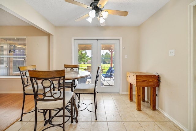 dining space with baseboards, a textured ceiling, ceiling fan, and french doors