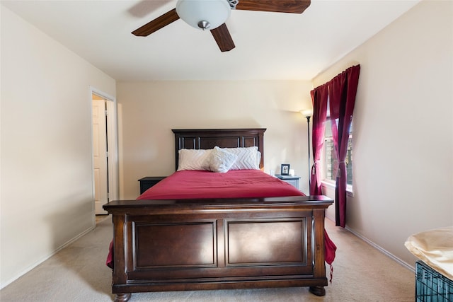 bedroom featuring baseboards, light colored carpet, and ceiling fan