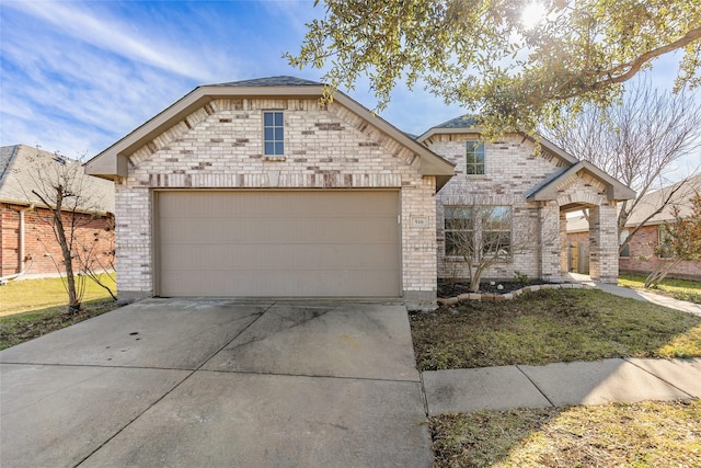 view of front of home with concrete driveway, brick siding, and an attached garage