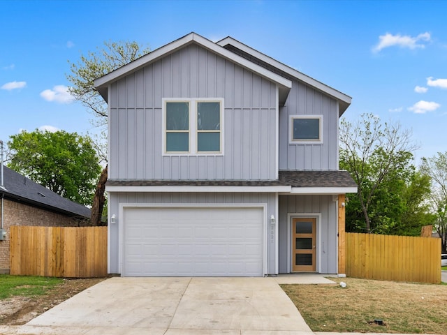 view of front of home with an attached garage, board and batten siding, fence, and driveway