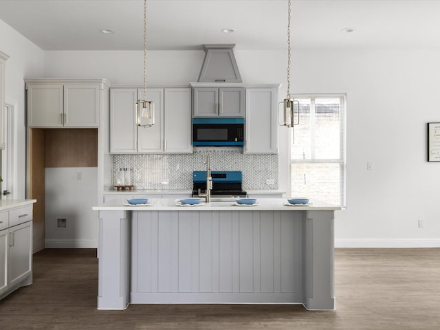kitchen with light countertops, decorative backsplash, stove, and dark wood-type flooring
