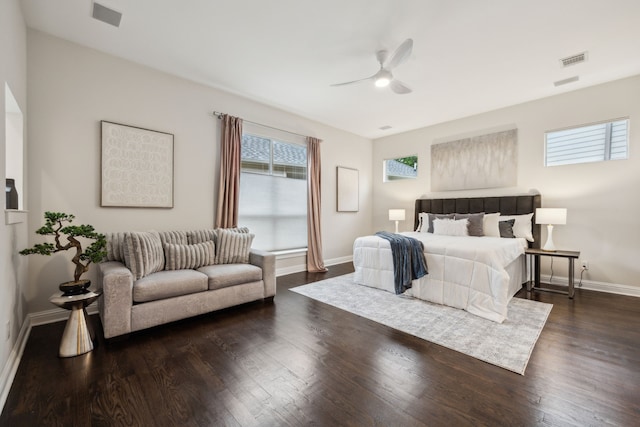 bedroom featuring visible vents, a ceiling fan, baseboards, and dark wood-type flooring
