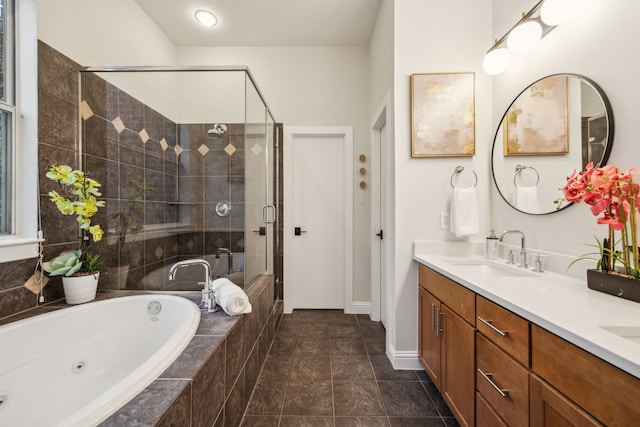 bathroom with double vanity, a jetted tub, baseboards, a sink, and a stall shower