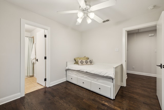 bedroom with visible vents, wood finished floors, baseboards, attic access, and ceiling fan