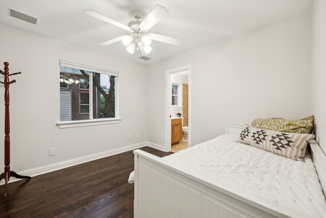 bedroom featuring dark wood-style flooring, ceiling fan, ensuite bath, baseboards, and visible vents