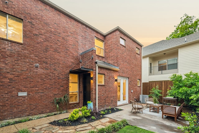 exterior space with brick siding, outdoor lounge area, a patio area, and cooling unit