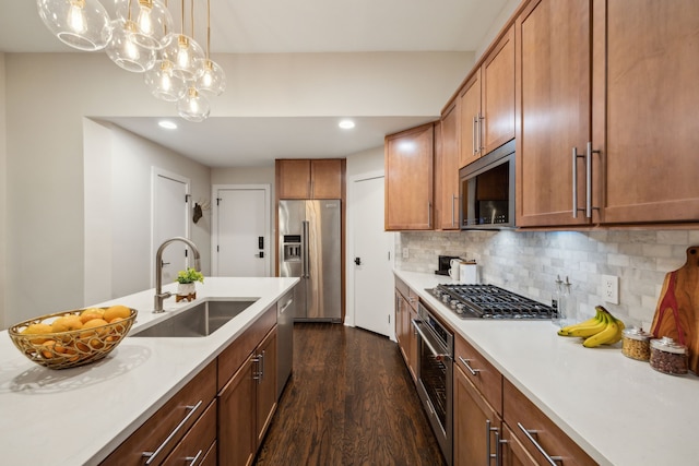 kitchen featuring appliances with stainless steel finishes, dark wood finished floors, a sink, light countertops, and recessed lighting