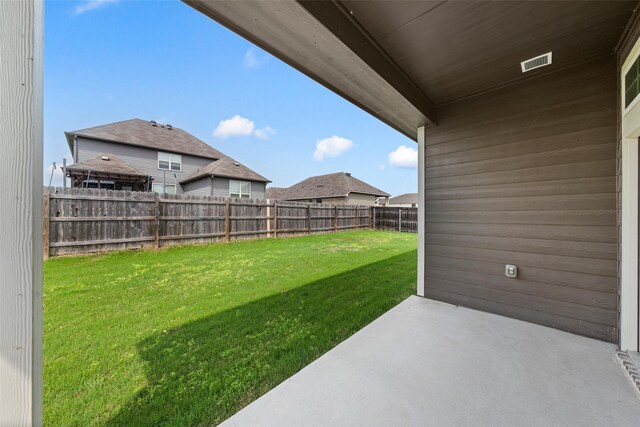 view of yard with a patio, a fenced backyard, and visible vents