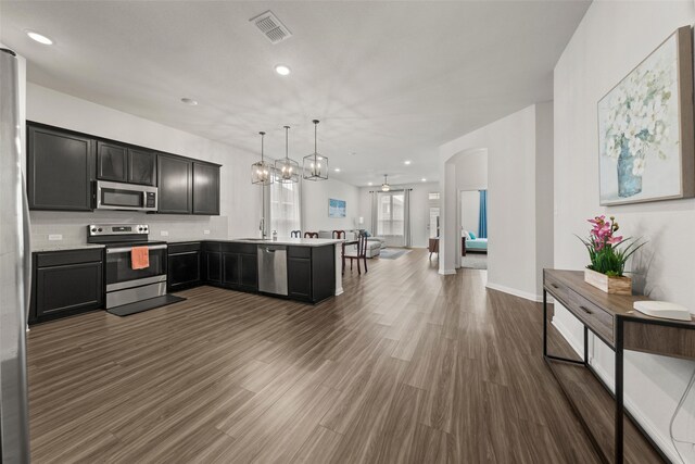 kitchen featuring visible vents, appliances with stainless steel finishes, light countertops, a peninsula, and open floor plan