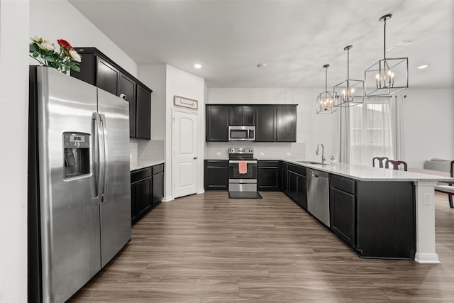 kitchen with decorative backsplash, a sink, a notable chandelier, stainless steel appliances, and recessed lighting