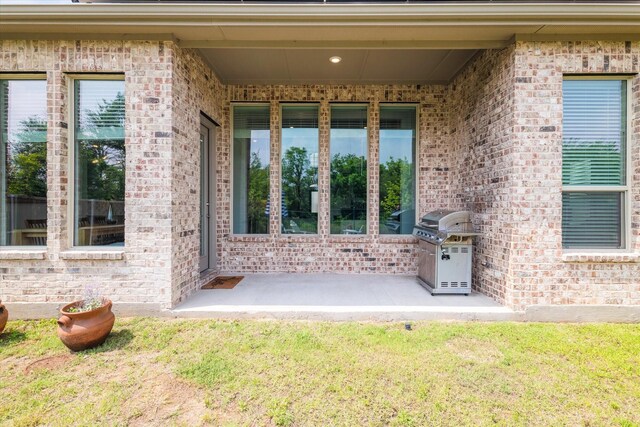 property entrance featuring brick siding and a lawn