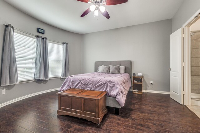 bedroom with baseboards, a ceiling fan, ensuite bathroom, and wood finished floors