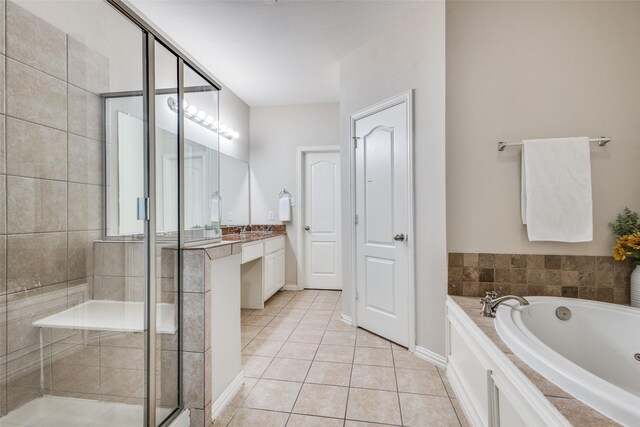 full bath with tile patterned flooring, vanity, baseboards, a bath, and a stall shower