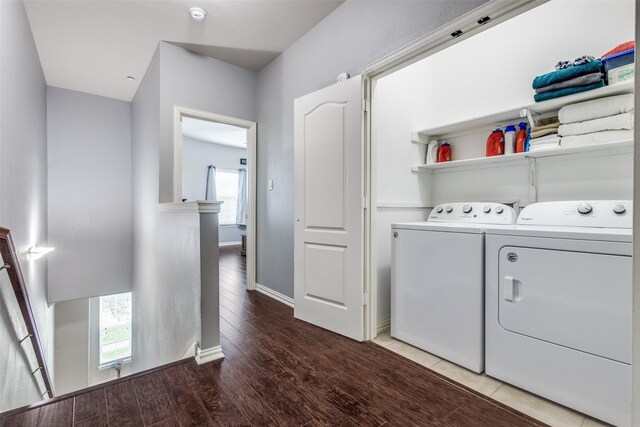 laundry area featuring washer and dryer, laundry area, baseboards, and wood finished floors