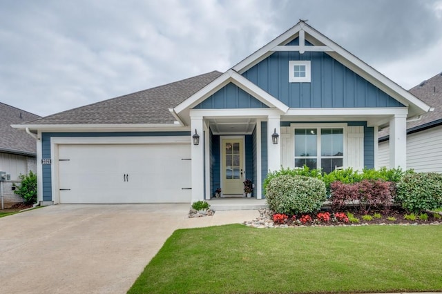 craftsman inspired home featuring a front yard, a shingled roof, board and batten siding, an attached garage, and driveway