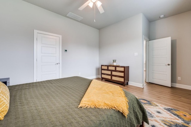 bedroom with visible vents, baseboards, ceiling fan, and wood finished floors