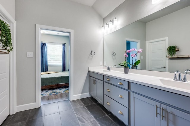 full bathroom with double vanity, a sink, baseboards, and tile patterned floors