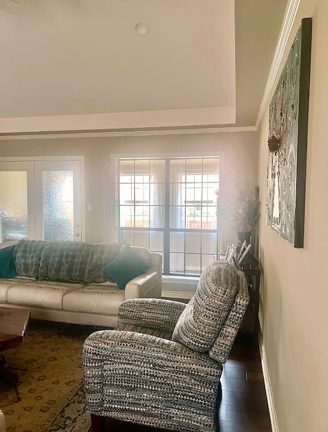 living room with crown molding, baseboards, and wood finished floors
