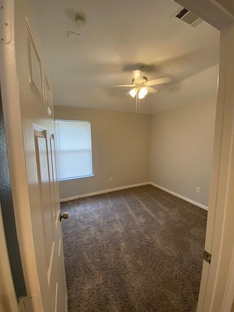 914 Gallant Fox Dr, Dallas, TX 75211 - unfurnished room with dark carpet, a ceiling fan, baseboards, and visible vents