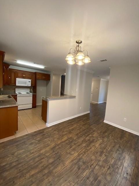 914 Gallant Fox Dr, Dallas, TX 75211 - kitchen with wood finished floors, a sink, a notable chandelier, white appliances, and open floor plan