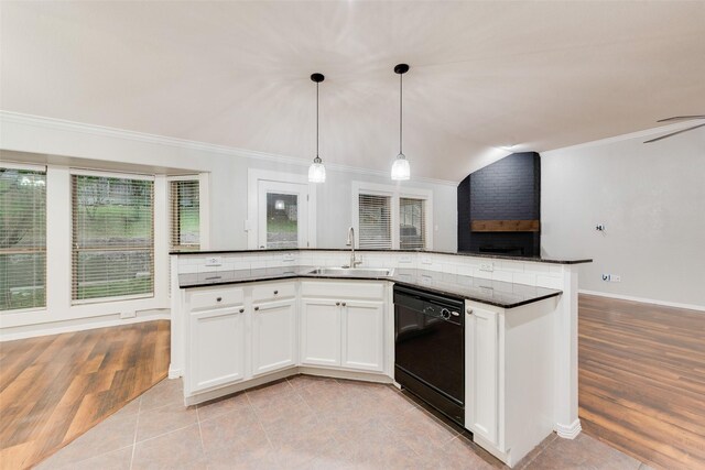 kitchen featuring crown molding, lofted ceiling, a sink, dishwasher, and decorative light fixtures